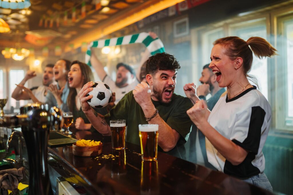 soccer fans celebrating a goal in the stadium crowd